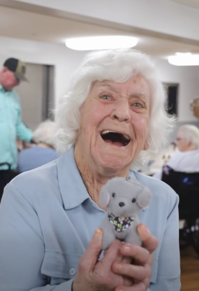 Very happy woman holding new stuffed puppy