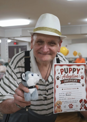 Smiling man holding newly adopted stuffed pup!