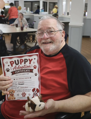 Smiling man holding newly adopted stuffed pup!