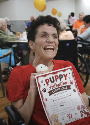 Very happy woman holding newly adopted stuffed puppy