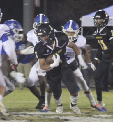 A Church Point runner faces a wall of West Feliciana players.