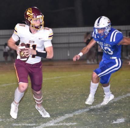 Iota quarterback Peyton Renfro looks to pass the ball as St. Ed's Copeland Miller closes in during the Nagata jamboree.