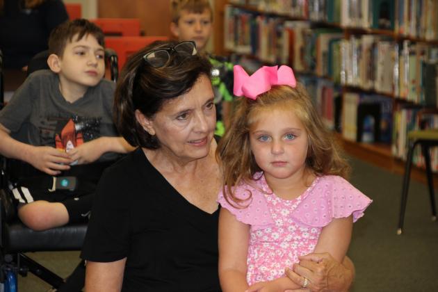 Debbie Frederick of Eunice holds her granddaughter Vivienne Sarver of Prarieville as Judy Kittles, children’s librarian, reads Mary Alice Fontenot’s, “Clovis Crawfish &amp; Batiste Bete Puante,” during Wednesday’s Story Time hour.