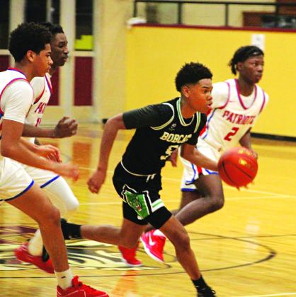 Devonte Johnson races past a trio of Ellender Patriots in 69-66 loss in Houma. (Photo by Rhett Manuel)