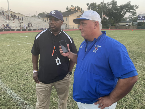 St. Edmund head coach James Shiver holds his phone as he and LaGrange head coach Maricco Wilson talk with a LHSOA official. (Photo courtesy of Barry Spears)