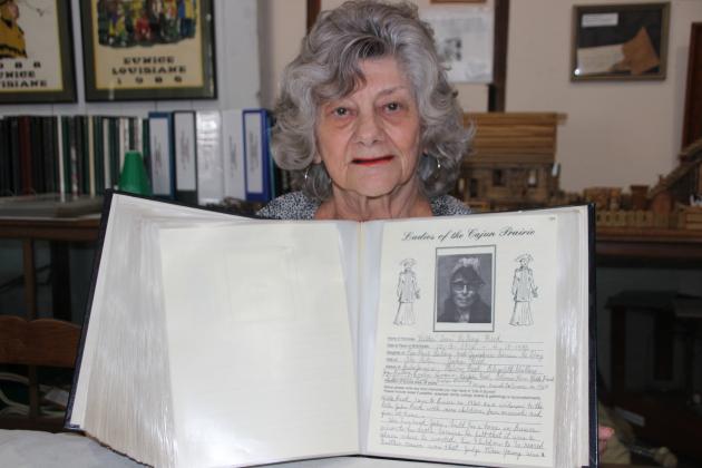 Lou Myers holds up a page that features  Hilda “Teen” Leday Reed, born Oct. 3, 1916, died April 18, 1985.