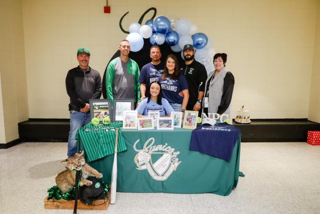Eunice High third baseman Alexis Ortego,sitting, recently signed to play softball at National Park College in Hot Springs, Arkansas. Standing, from left, are assistant softball coach Ryan Vienne, EHS athletic director Andre Vige, father Mike Doucet, mother Lessie Doucet, head coach ball coach Trenon Trosclair and EHS principal Irma Trosclair. (Photo by Bailey Turner)