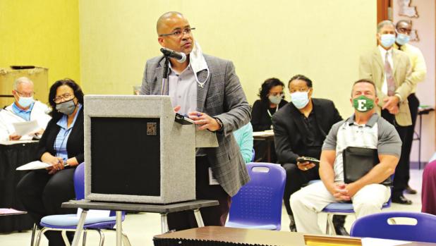 Jerome Robinson, at the lectern, speaks about athletic facility needs in St. Landry Parish public schools at a meeting Monday in Opelousas. Seated at right is Eunice High School Principal Mitch Fontenot. (Photo by Harlan Kirgan)