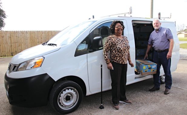 Mary Ann Guillory, Food Bank director, and David Guillory with a new van from Bob Giles. (Photo by Myra Miller)
