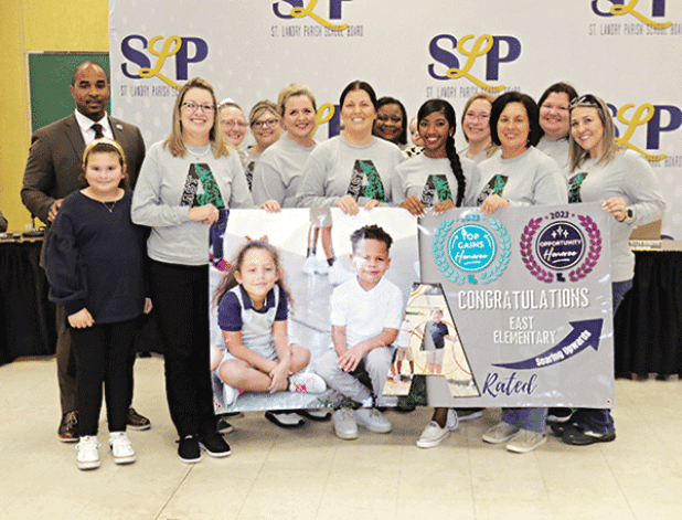 East Elementary in Eunice was recognized as an A-rated school in the state accountability scoring for 2023. A banner was presented to the school at Thursday’s St. Landry Parish School Board meeting. At left is Superintendent Milton Batiste. Holding the banner at left is Principal Gina LaGrange. Others in the photos are faculty members and their children. (Photos by Harlan Kirgan)