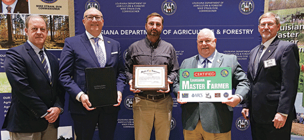 Trent Broussard, of Acadia Parish, was designated a Louisiana Master Farmer at a Jan. 12 ceremony. From left, are Michael Salassi, director of the Louisiana Agricultural Experiment Station; Matt Lee, interim LSU vice president for agriculture; Broussard; Mike Strain, commissioner of the Louisiana Department of Agriculture and Forestry; and Chad Kacir, of the Natural Resources Conservation Service. (Photo by Olivia McClure/LSU AgCenter)