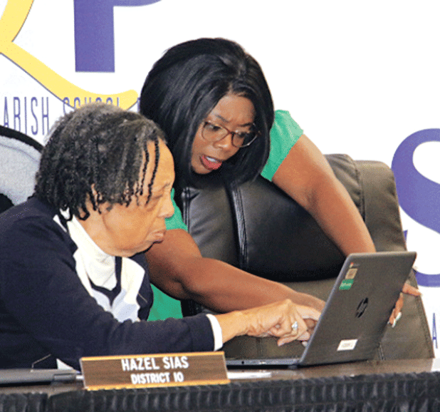 St. Landry Parish School Board members Hazel Sias and Timmakah Hardy confer at Monday’s meeting. (Photo by Harlan Kirgan)