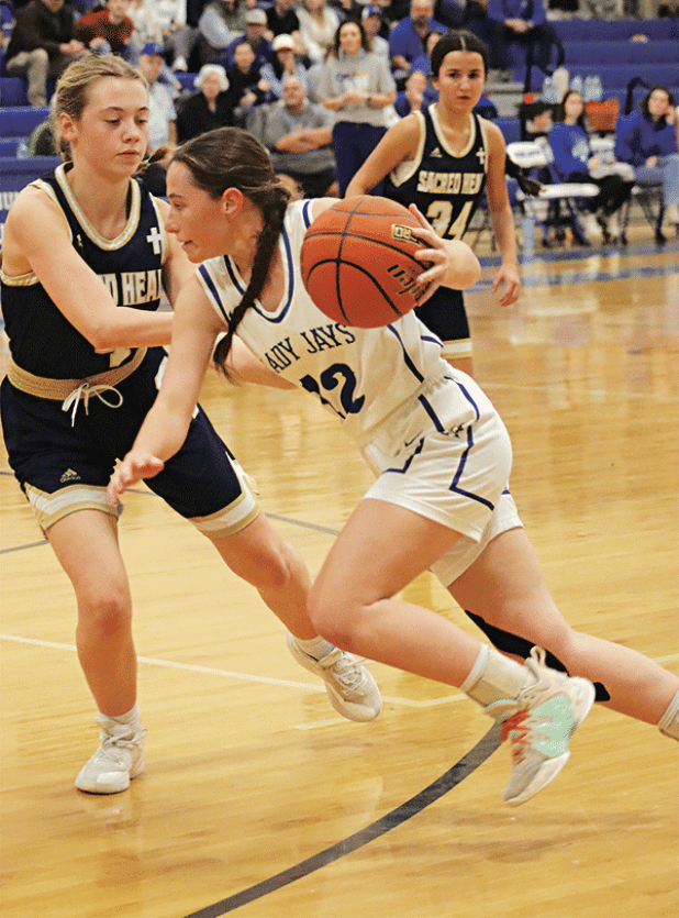 St. Edmund’s Caroline Lavergne drives past Sacred Heart defenders as the Lady Jays win 56-38. (Photo by Amy Myers)