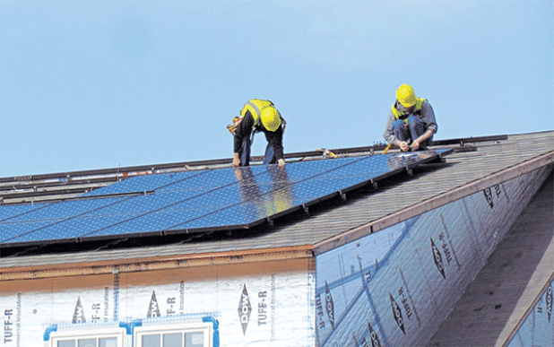 Workers install solar panels on the National Institute of Standards and Technology’s (NIST) Net-Zero Energy Residential Test Facility in Gaithersburg, Maryland. Solar for All, a federally funded program to provide rooftop and community solar to low-income residents, is on hold after President Donald Trump declared a freeze on funding climate-related projects and other spending. (Photo courtesy of NIST) 