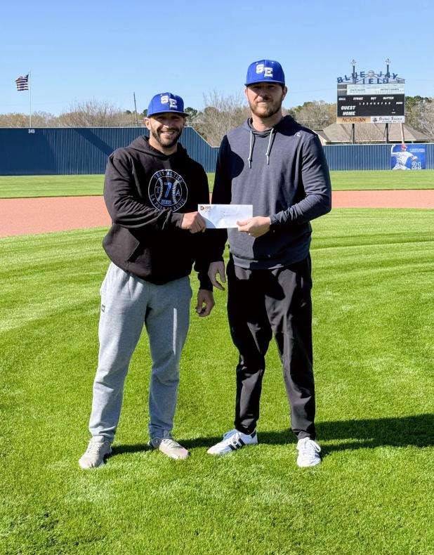 St. Edmund head coach Casey Charlie, left, and Stefan Frey of Frey Development stand at the Blue Jay Field as Frey Development announces its sponsorship of the upcoming Frey Development Prep Classic, set for Feb. 26–28.