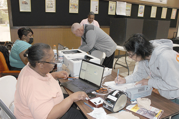 Charlene Papillion and Bertman Papillion of Swords cast their votes at Eunice City Hall during early voting Wednesday morning. Also shown are Commissioners Cynthia Martin and Alexis Gallien. Voting in the front page photo is Eveline Ardoin. (Photo by Myra Miller)