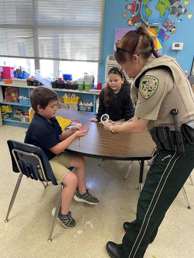 Lt. Regina Rinaldi, with the St Landry Parish Sheriff’s Department DARE program, demonstrates the use of her hand cuffs after the weekly DARE lesson at East Elementary.