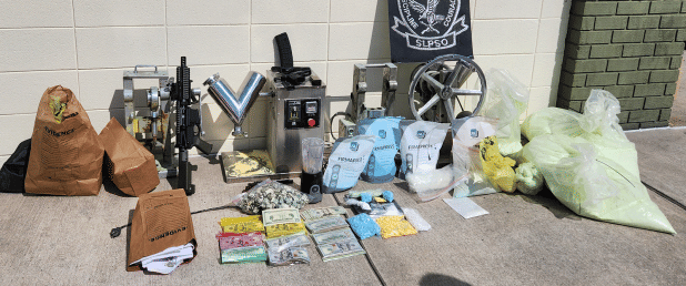 Drugs, guns and pill-making gear seized in drug bust. (St. Landry Parish Sheriff's Office photo)