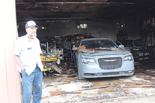 Kurn Semien, 70, stands by the fire-damaged paint and body shop he owns at 601 E. Laurel Ave., Eunice, on Tuesday. Fire damaged the shop on Monday. (Photo by Myra Miller) 