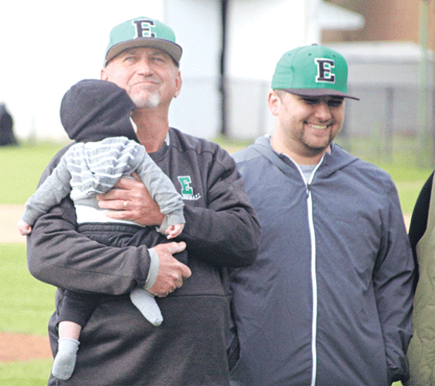Eunice High head coach Scott Phillips is holding his grandson, Tommy, during Scott Phillips Day prior to Eunice’s game against Oakdale on Monday. In 33 seasons as a head coach, 31 at Eunice High, Phillips has accumulated nearly 700 wins. He’s also recorded 31-straight playoff appearances, 22 seasons of 20 or more wins and 15 district championships in a decorated career. At right is his son, Austin, (Photo by Rhett Manuel) 
