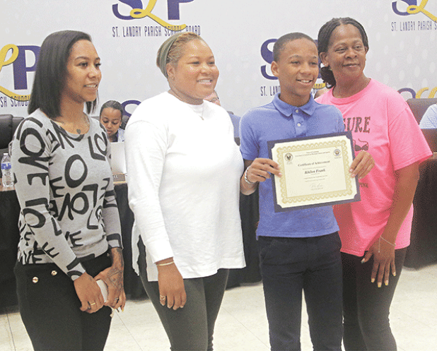 Khilon Frank, a Central Middle School student, holds a certificate for his performance in the Louisiana Elementary State Championship Fitness Meet Governor’s Games at the May 1 St. Landry Parish School Board meeting. Frank placed third in the state games in standing long jump. From left, are Kierra Poullard, his mother; Tamika Zachary, health and physical education teacher at Creswell Middle School in Opelousas, Frank; and Abigail Semien, Frank’s grandmother. Zachary organized the parish games at Northwest 
