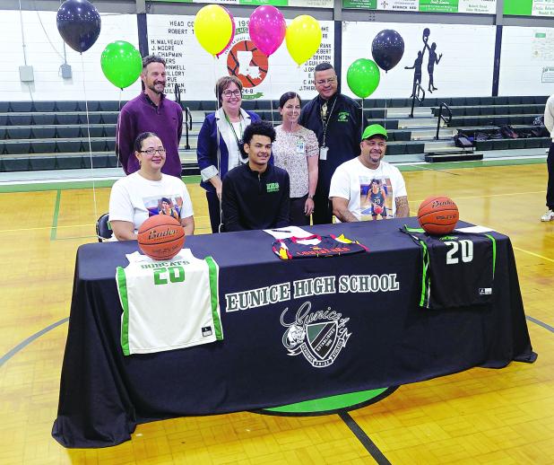 Eunice High senior DeAndre Reed is all smiles after signing a Letter of intent to play at Lafayette’s Community Christian College. He is pictured with his parents and Eunice High administrators Chad Andrepont, Irma Trosclair, Rachel Smith and Dexter Brown. (Photo by Rhett Manuel)