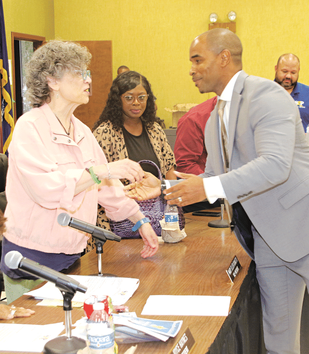 Newl elected St. Landry Parish School Superintendent Milton Batiste II, right, is congratulated by School Board member Mary Ellen Donatto, left, as Board member Timmakah Hardy, center, looks on at Wednesday’s meeting. Board member Robert Gautreaux is at far right. Batiste won the superintendent’s job on a 12-1 vote. (Photos by Harlan Kirgan)
