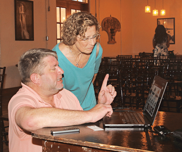 Celeste Gomez looks over a plan for downtown Eunice with presenter Tripp Muldrow at a meeting Thursday at Gabrielle’s. (Photo by Harlan Kirgan)