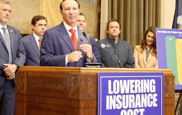 Gov. Jeff Landry speaks to reporters about his legislative agenda to bring down high auto insurance rates on April 9. Also shown, second from right, is House Speaker Phillip DeVillier, of Eunice.  (Photo byWes Muller/Louisiana Illuminator)