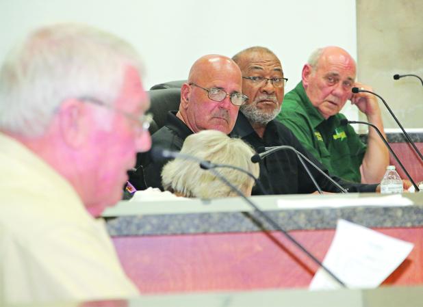St. Landry Parish Council Chairman Wayne Ardoin, left, reads a document at Tuesday’s meeting as Council members, from left, Timmy Lejeune, Jimmie Edwards and Ernest Blanchard listen. (Photo by Harlan Kirgan)