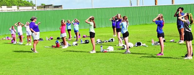 LSUE Softball Coach Meghan Collins leads girls in warm up drills Thursday morning before the camp begins. (Photo by Myra Miller)