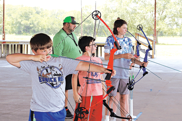 Above, from left, are Landry LeJeune, of Basile, Andre Guillory, of Eunice, and Max Daniel, of Baton Rouge, practice archery. Johnson is in the background. 