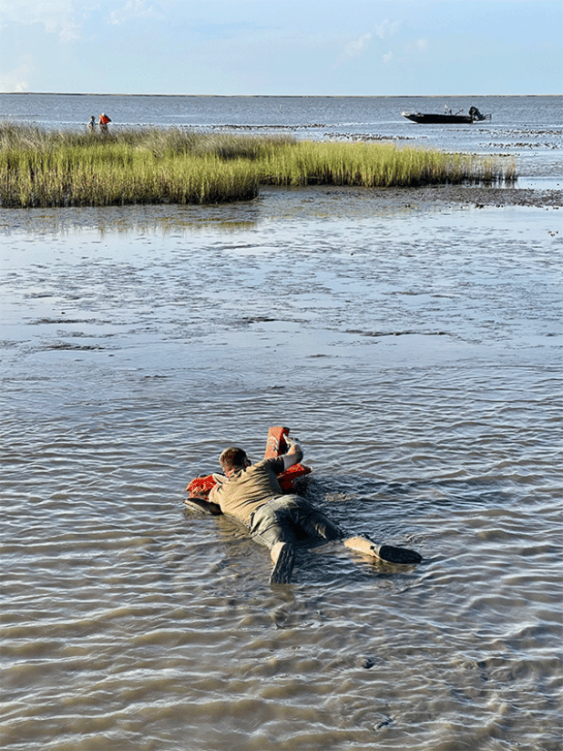 Senior Agent Joshua Segrest makes his way through the mud to get to the stranded boaters. (Louisiana Department of Wildlife and Fisheries photo)