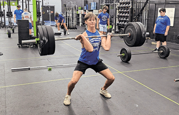 Owen Cart, a junior defensive back for the St. Edmund High School football team, builds strength in preparation for the coming season. James Shiver, head football boach, believes if a team has 10 or more players who can power clean 225 pounds or more they stand a good chance of becoming a state title contender. (Photo by Rhett Manuel)