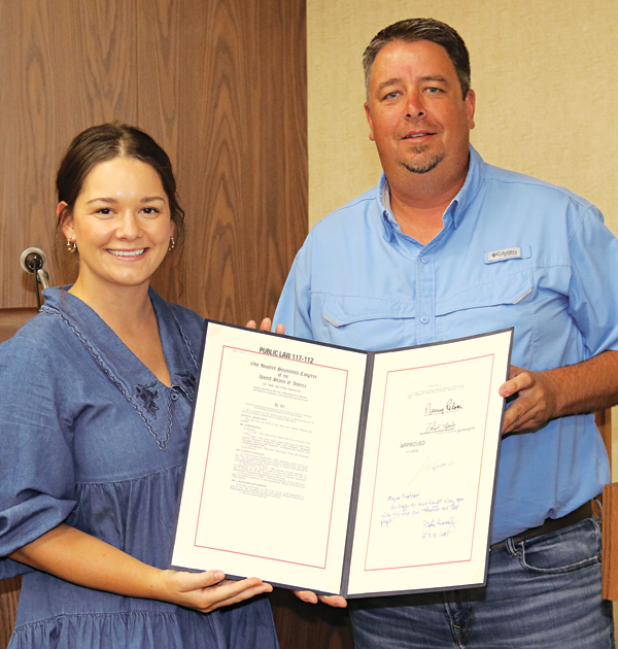 Sarah Dake, a representative from U.S. Sen. John Kennedy’s office, presents a document to Eunice Mayor Scott Fontenot signifying the transfer of the Liberty Theatre Annex from the U.S. Park Service to the city at Tuesday’s Board of Aldermen meeting. (Photo by Harlan Kirgan)