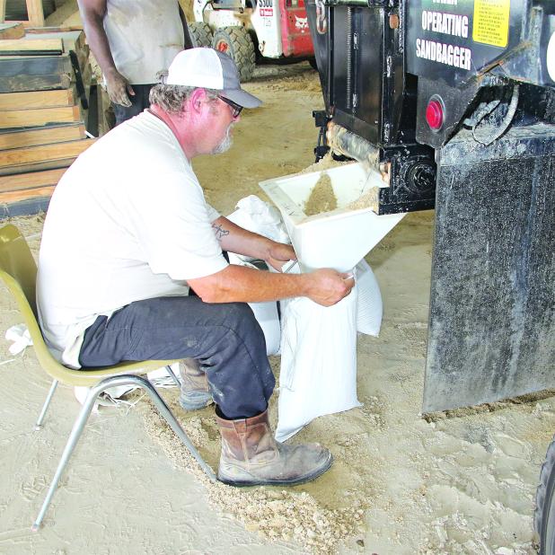 St. Landry Parish Government worker David Courville fills sandbags at the Yambilee Building in Opelousas on Tuesday afternoon. (Photo by Harlan Kirgan.
