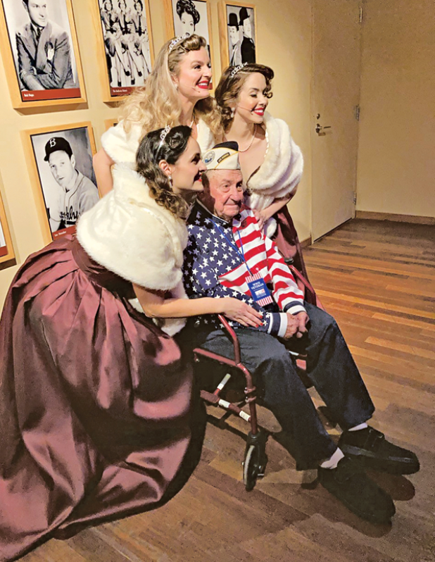 Richard has his photo taken with the National WWII Museum’s Victory Belles, a vocal trio that performs music from the 1940s. Richard visited the museum last year for the 80th anniversary of the attack on Pearl Harbor, and he was the only survivor to attend the event. (Photo courtesy of Connie Figueron)
