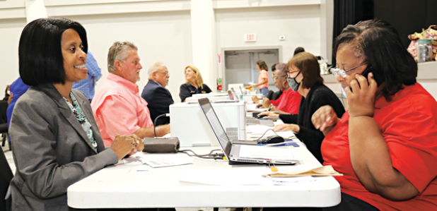 Eunice Alderwoman Germaine Simpson, left, was first in line for qualifying Wednesday morning at the Delta Grand in Opelousas. Cynthia Martin, right, assists Simpson. Also at the table qualifying,  are Carroll Snyder, qualifying for Krotz Springs mayor; Kyle LeBouef, qualifying for Eunice police chief; and Susie Snyder, Krotz Springs police chief. (Photos by Harlan Kirgan)