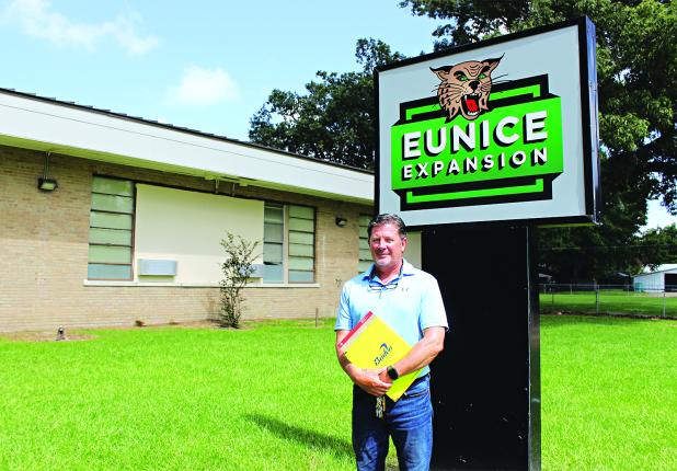 Charles Vidrine, administrator at Eunice Expansion, stands by the new sign at the former Eunice Elementary on Monday. (Photo by Myra Miller)