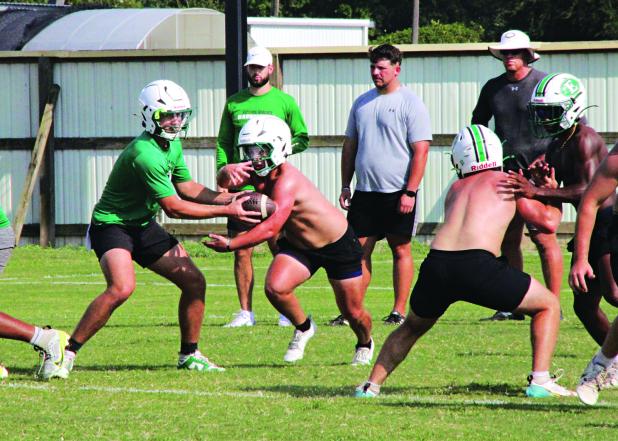 Senior quarterback Montana Brown handing ball off to senior running back Parker Pedigo during a Bobcat fall camp session. (Photo by Rhett Manuel)