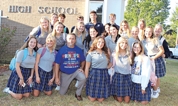 Mitchell Fontenot, principal at St. Edmund Catholic School, is surrounded by seniors on the first day of school Wednesday. Fontenot had been principal at Eunice High School. (Photo by Myra Miller)