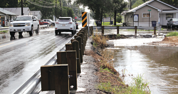 Water rolls off South 5th Street at the intersecton with West Maple Avenue during Tuesday’s storm that flooded many streets in Eunice. (Photo by Harlan Kirgan)