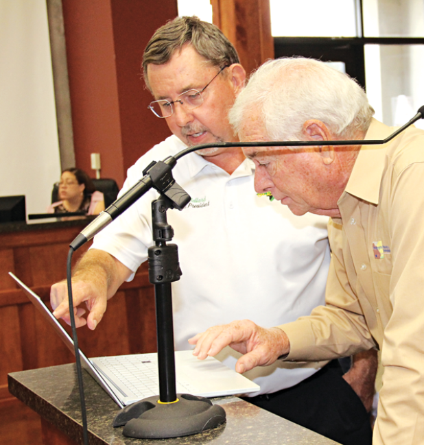 St. Landry Parish President Jessie Bellard, left, and demographer Mike Hefner look over voting precincts on a computer during Wednesday’s Parish Council meeting. Voters are receiving voter identification cards and if they questions should call the Registrar of Voters Office. (Photo by Harlan Kirgan)