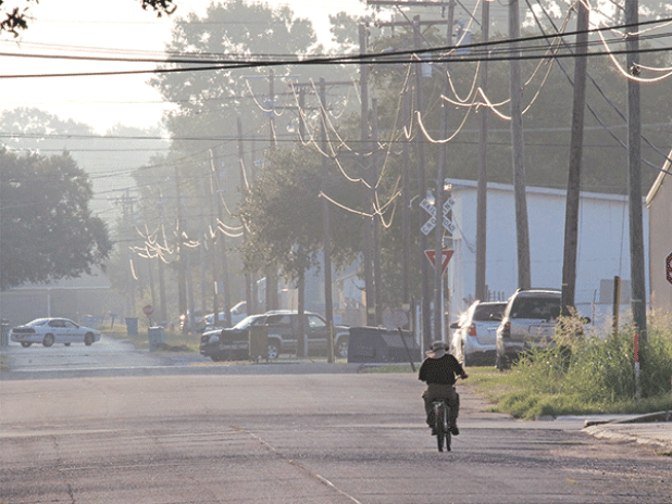 Early morning temperatures in the low 70s last week made riding a bicycle comfortable. This  bicycle rider was on East Vine Street at about 7 a.m. Wednesday. (Photo by Harlan Kirgan)
