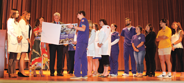 U.S. Sen. Bill Cassidy looks at a “Thank You” from LSUE during a presentation on Friday of a $1 million grant to upgrade LSU Eunice’s Allied Health laboratory equipment. Third from left, is Chancellor Nancee Sorenson. (Photo by Myra Miller ) 