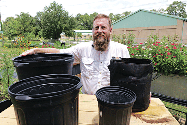 LSU AgCenter horticulture agent Will Afton stands with some different types of containers that can be used for gardening. (Photo by Randy LaBauve/LSU AgCenter)