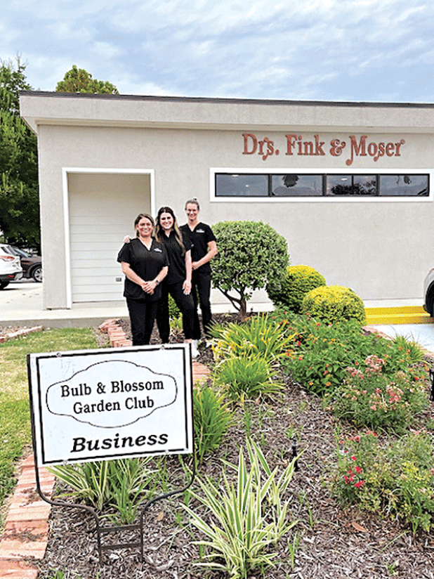 The Bulb & Blossom Club of Eunice awarded the August Business Yard of the Month to Drs. Fink & Moser located at 301 South 2nd. The landscaping features vinca, coleus, day lilies, foxtail ferns and a variety of shrubbery.  From left are Kylie Doucet, Katelyn Smith and Sadie Carrier. (Submitted photos)