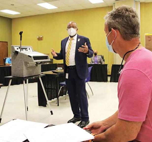 Patrick Jenkins, standing, St. Landry Parish school superintendent, addresses a committee of the whole meeting Thursday on capital improvement plans. At right is Lyn Henley, a consultant from Volkert Inc. (Photo by Harlan Kirgan)