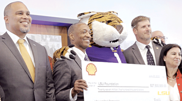Shell, one of the biggest oil companies in the world, gave $27.5 million to LSU in 2022 to fund the university’s Institute for Innovation in Energy. LSU President William F. Tate IV, second from left, poses with LSU mascot Mike the Tiger. A new paper calls for additional research into the influence of the fossil fuel industry on academia. (LSU photo) 