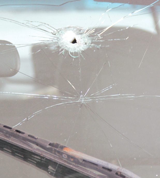 A bullet hole in the windshield of the Ford Escape. 